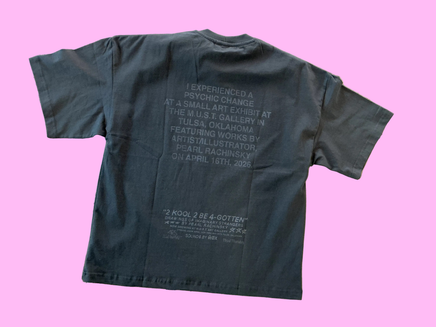 Black t-shirt with text on the back on a textured surface