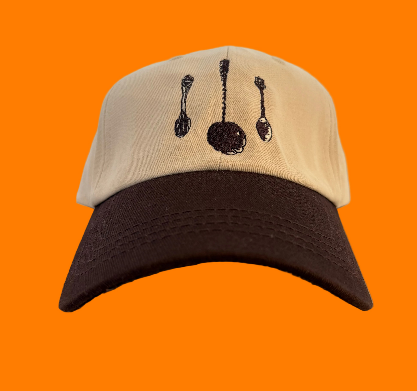 Tan baseball hat with dark brown bill and brown embroidered spoons on the front.