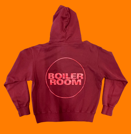 Back of brick red hoodie with large Boiler Room logo screen printed in bright bed.