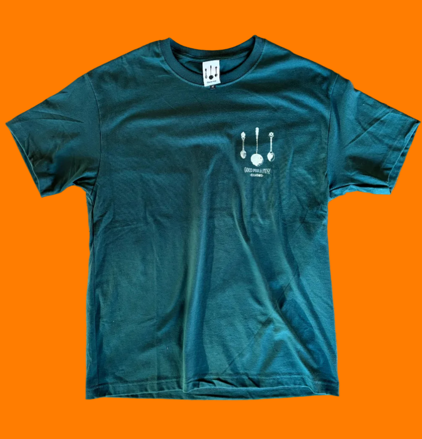 Hunter green tee shirt with cream Souvenirs design screen printed on the left chest.
