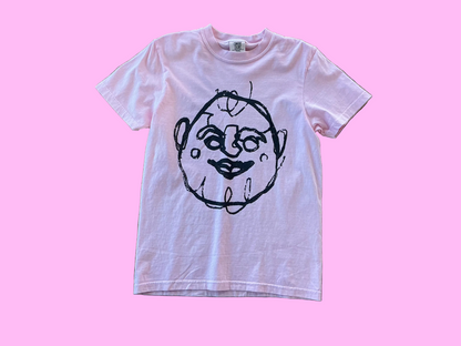 Pink t-shirt with a black graphic design on a textured surface