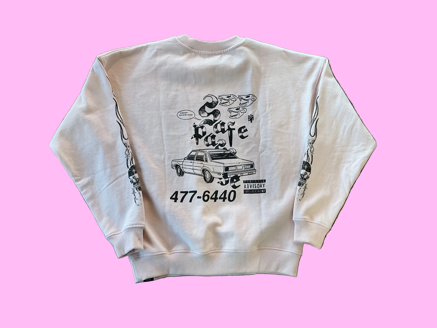 Pink sweatshirt with black graphics on a textured surface