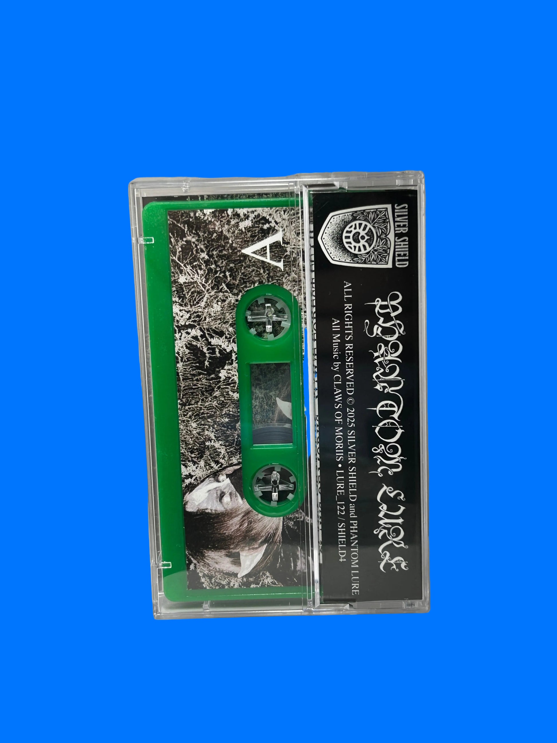 Cassette tape with a black and green label inside a white cassette player.