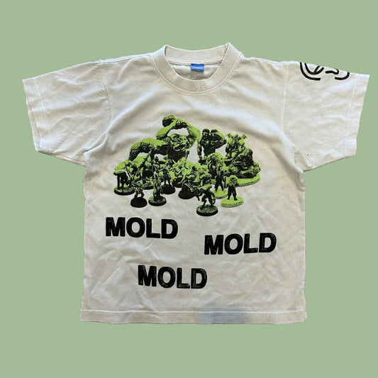 White t-shirt with green mold-like design and 'MOLD' text on a concrete floor.