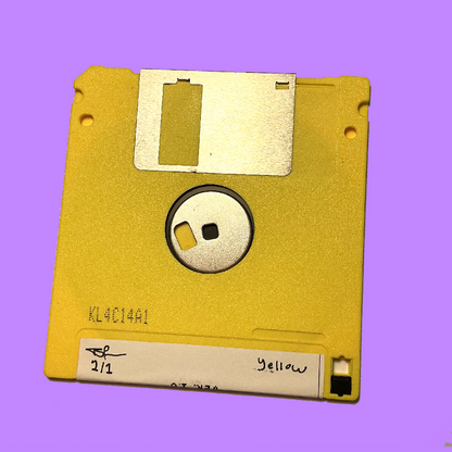 A vintage yellow 3.5-inch floppy diskette with a silver metal shutter and a white paper label, shown against a solid purple background.