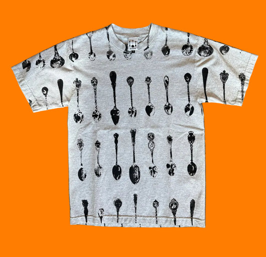 Front of the BY.Everyone heather grey shirt with all-over spoon pattern print in black.